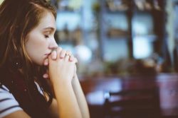 Woman praying listening to God speak to her